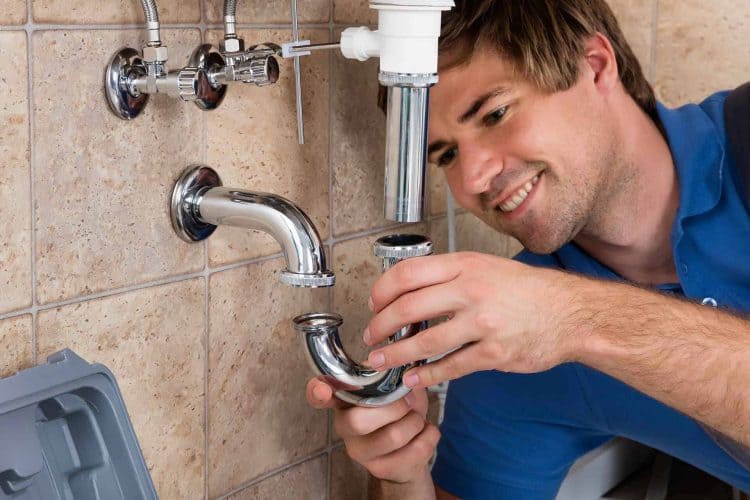 Technician placing part on pipes