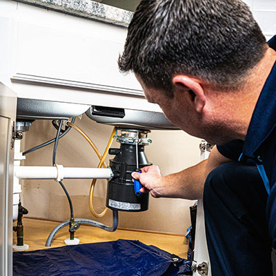 Z PLUMBERS service technician fixing garbage disposal