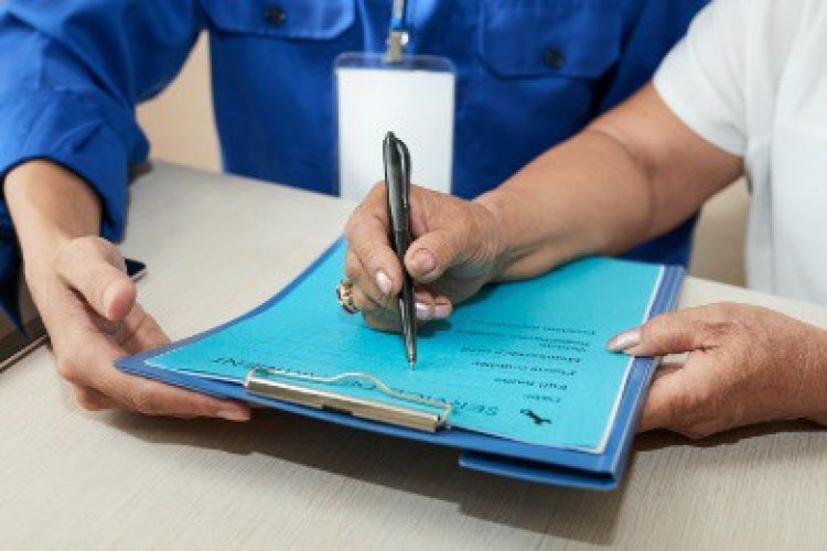 Close-up of hand writing on clipboard