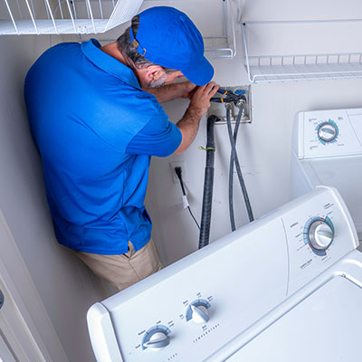 Service technician working on clothes washer