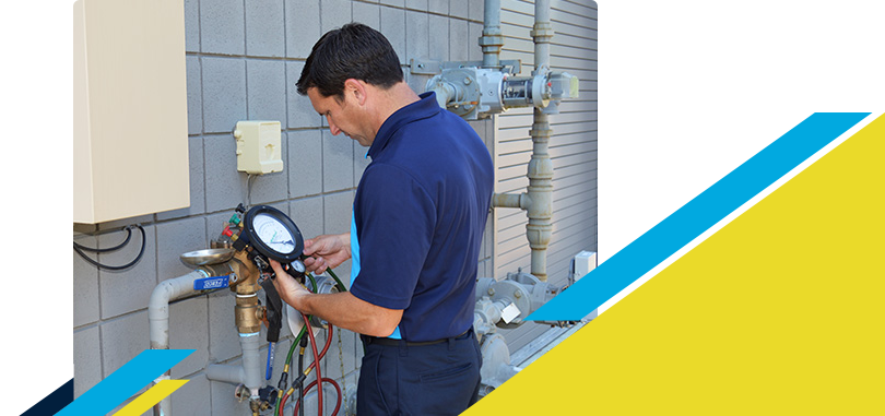 Z PLUMBERZ technician using a tool to measure backflow