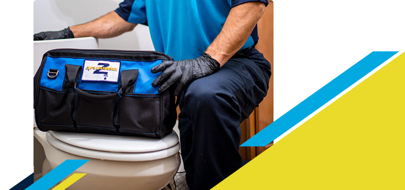 Z PLUMBERZ technician kneeling with tool bag on toilet