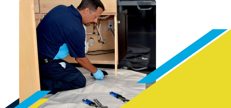 Z PLUMBERZ of Palm Beach technician inspecting pipes under kitchen sink